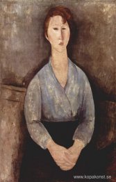 Sittande kvinna klädd i blå blus