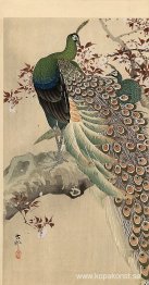 Två gröna påfåglar på grenen av ett blommande träd