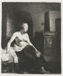 Kvinna som sitter halvt klädd bredvid en spis Kvinna som sitter halvt klädd bredvid en spis